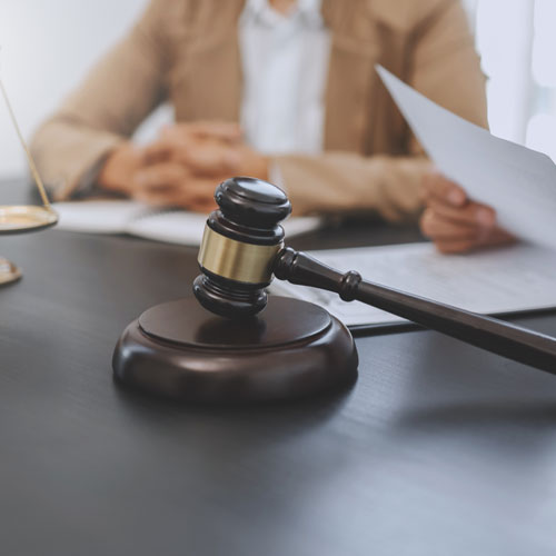 Lawyers sitting at table with gavel and hammer